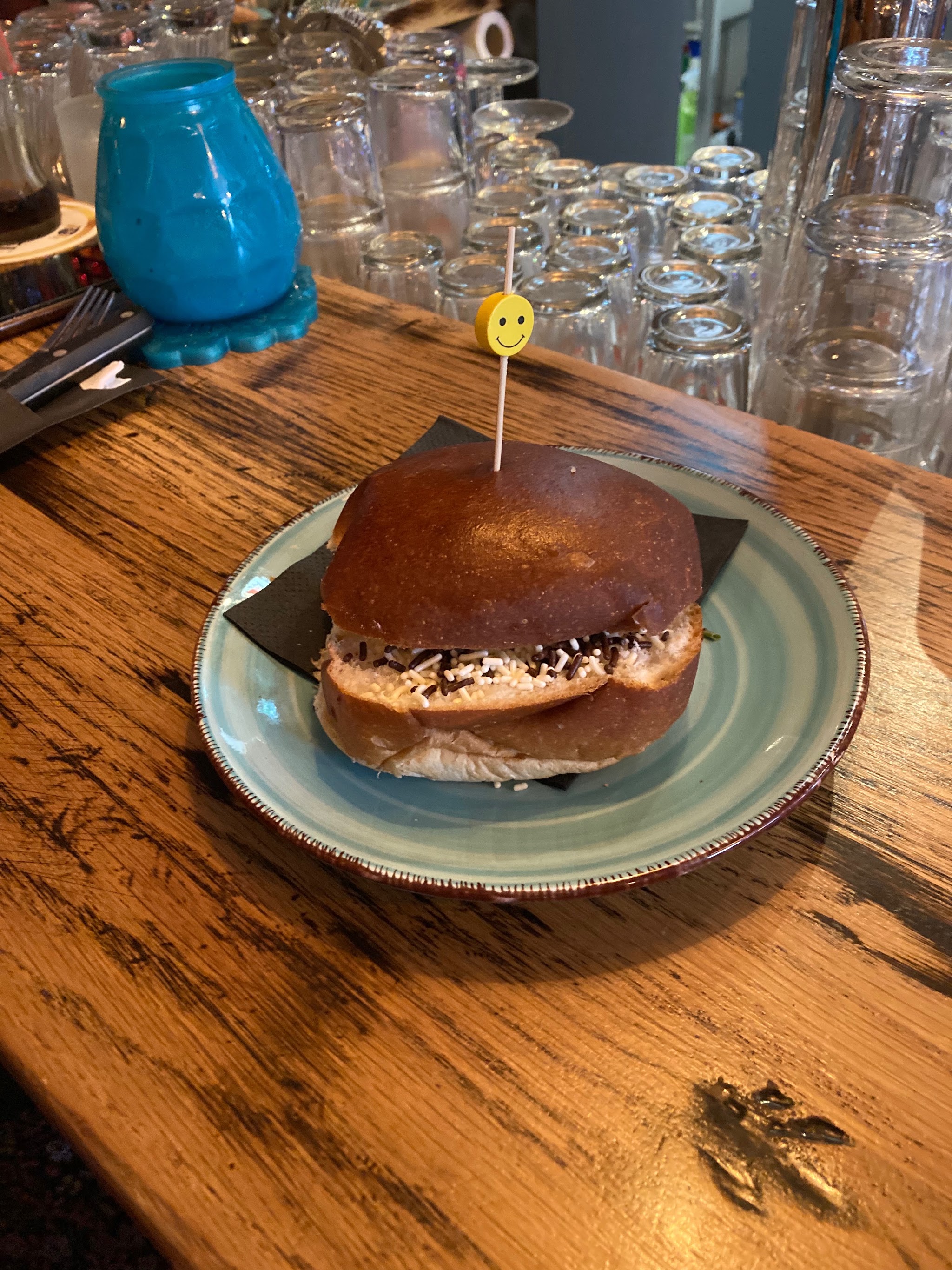 Een broodje geserveerd op een bord op de houten tafel in de bistro